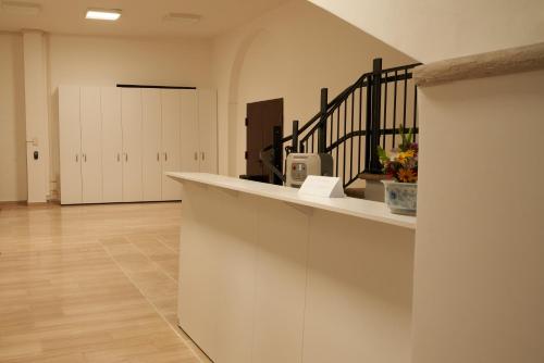 a room with a counter and a hallway with white cabinets at HUB Portanova in Trani