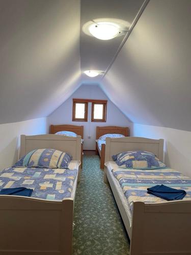 two beds in a room with a attic at Góbé Vendégház in Sovata