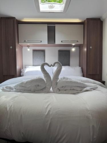two swans made out of towels on a bed at Tayys Inn Luxury Camp in Birmingham