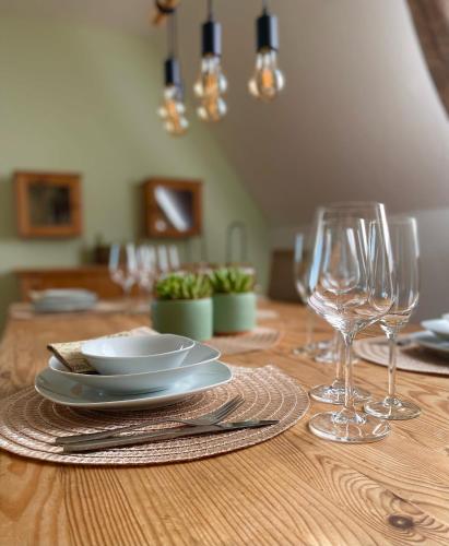 a wooden table with plates and wine glasses on it at Ferienwohnung Steinhoff in Nordkirchen