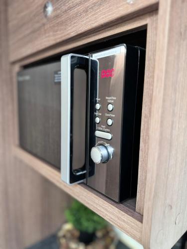 a microwave oven with the door open on a wooden cabinet at Tayys Inn Luxury Camp in Birmingham