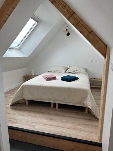 une chambre avec un lit dans un grenier dans l'établissement Bel appartement vue mer ETEL, à Étel