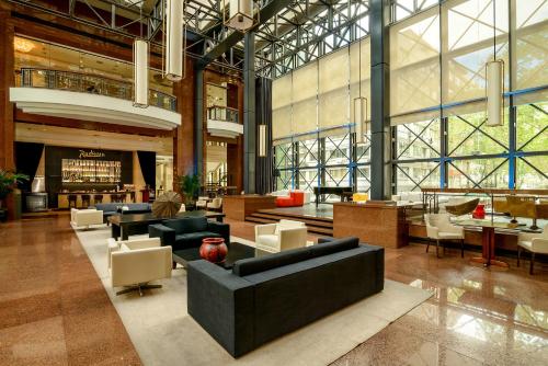 a lobby with couches and chairs in a building at Radisson Montevideo Victoria Plaza Hotel in Montevideo