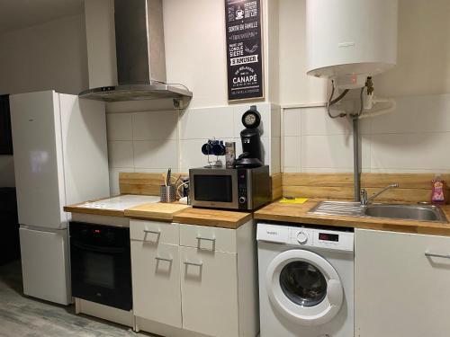 une cuisine avec un lave-linge et un micro-ondes dans l'établissement STUDIO ÉQUIPÉ A 50 MÈTRE DE LA GARE ET 10 MN DES PLAGE, à Sète