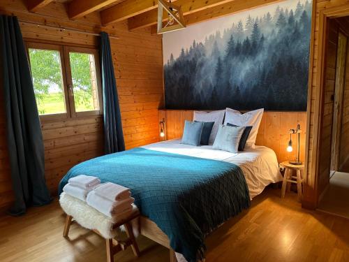 une chambre avec un lit et un tableau au mur dans l'établissement Chalet dans un écrin de verdure avec SPA privatif, à Jeanménil