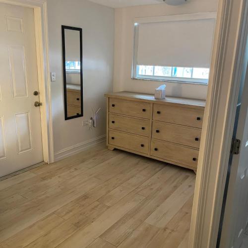 a bedroom with a dresser and a window and a mirror at Kings Kamp in Key Largo