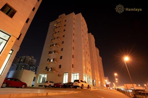 a building at night with cars parked in front of it at hamlaya apartments هملايا للشقق الفندقيها لفروانيه in Kuwait