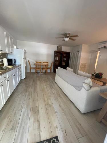 a living room with a white couch and a kitchen at Kings Kamp in Key Largo