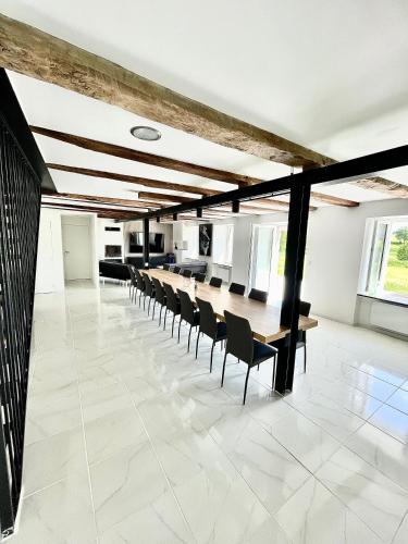 une salle de conférence avec une longue table et des chaises dans l'établissement Gîte D'Ozange, à Veyrières