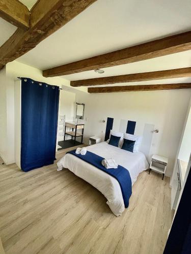 - une chambre avec un grand lit et un rideau bleu dans l'établissement Gîte D'Ozange, à Veyrières