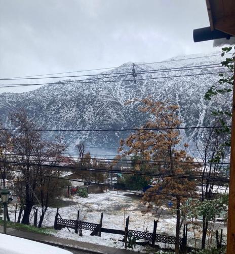 a snow covered mountain in the background with benches at Cabañas del Maipo - Cabaña Maipo in San José de Maipo