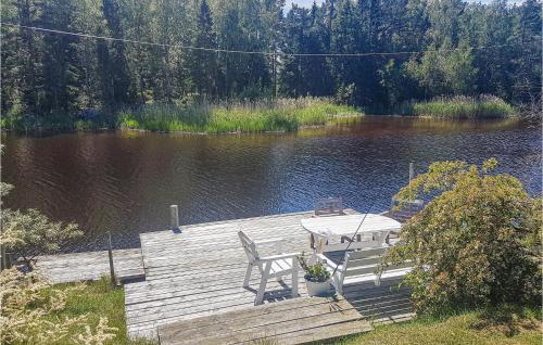 a table and chairs sitting on a dock on a lake at Nice Home In Ljusne With Wifi in Ljusne