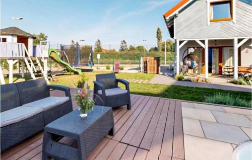 eine Terrasse mit einem Sofa, Stühlen und einem Spielplatz in der Unterkunft Pet Friendly Home In Karwia in Karwia