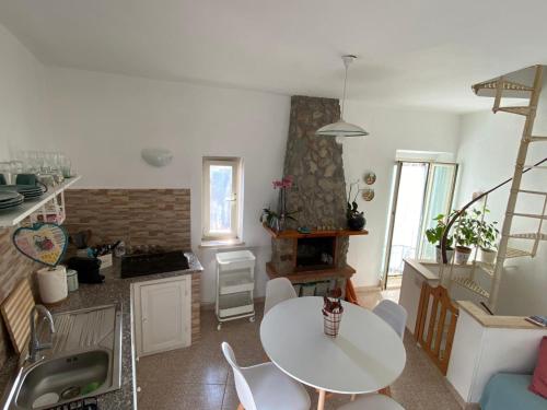 a kitchen with a white table and a table and chairs at La torretta nel borgo in Ronciglione