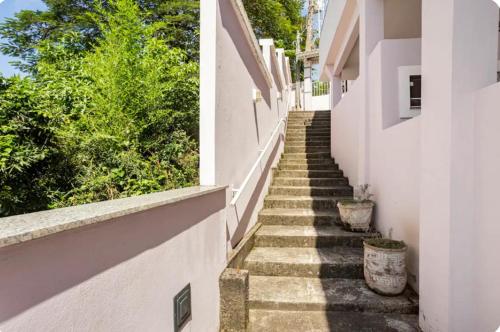 a stairway leading up to a white building with stairs at Casa Raio de Sol em Conservatória in Conservatória