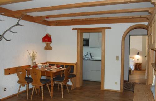 eine Küche und ein Esszimmer mit einem Holztisch und Stühlen in der Unterkunft Ferienwohnung mit Balkon I Bergblick I Parkplatz Apartment ONE in Bad Hindelang