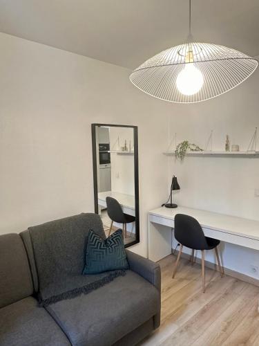 un salon avec un canapé et un miroir dans l'établissement Moderne et lumineux, à Asnières-sur-Seine