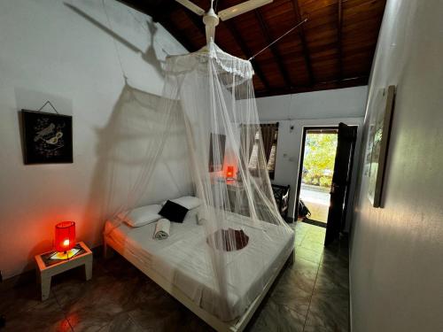 a bedroom with a bed with a mosquito net at Full Moon Resort in Unawatuna