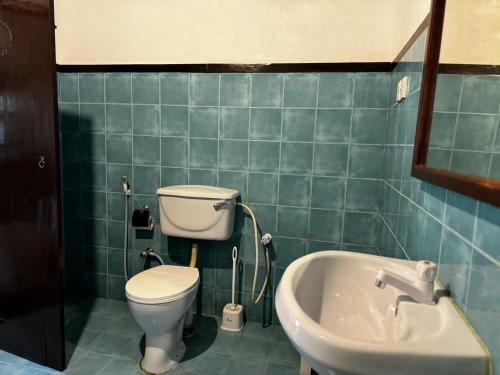 a bathroom with a toilet and a sink and a tub at Full Moon Resort in Unawatuna