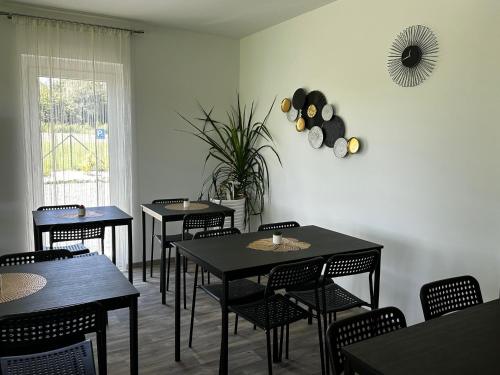 a dining room with tables and chairs and a window at See Panzió in Fertőrákos