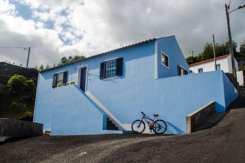 a bike parked in front of a blue building at Sunrise House in Companhia de Baixo