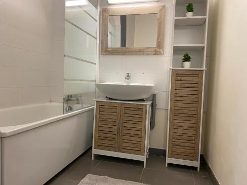 une salle de bain avec un lavabo et une baignoire dans l'établissement Le grand Logis, à Royan