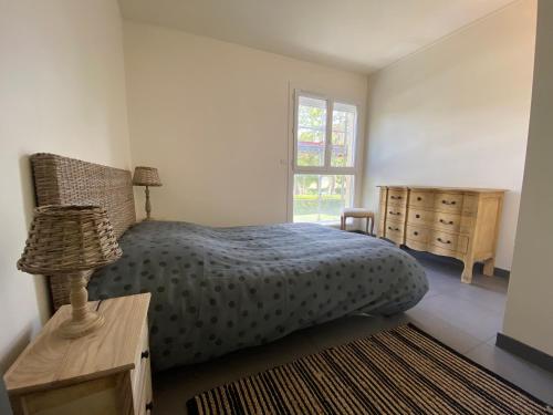 une chambre avec un lit, une commode et une fenêtre dans l'établissement Le grand Logis, à Royan