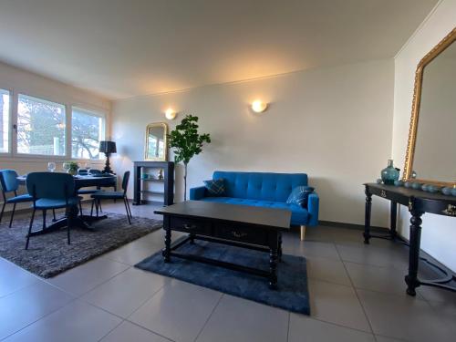 un salon avec un canapé bleu et une table dans l'établissement Le grand Logis, à Royan