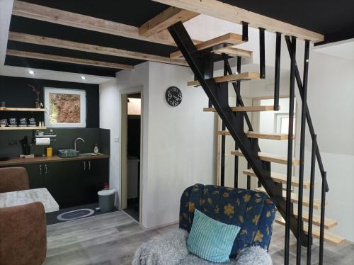 a living room with a spiral staircase in a house at Planinska vila KTM Lisine in Despotovac