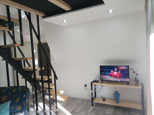 a room with a staircase and a television on a table at Planinska vila KTM Lisine in Despotovac