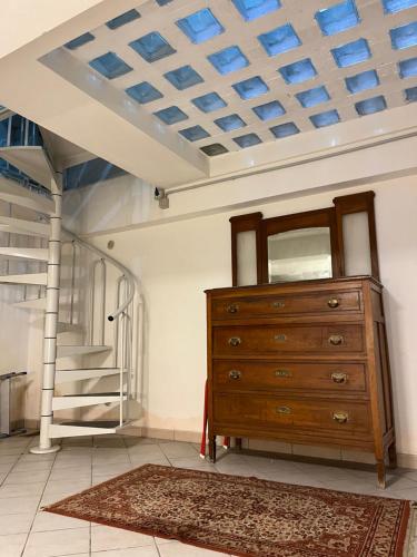 a room with a wooden dresser and a staircase at Casa nel Liberty in Canicattini Bagni