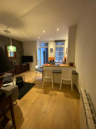 une cuisine et un salon avec une table et des chaises dans l'établissement Appartement - Bonlieu - Annecy vieille ville, à Annecy