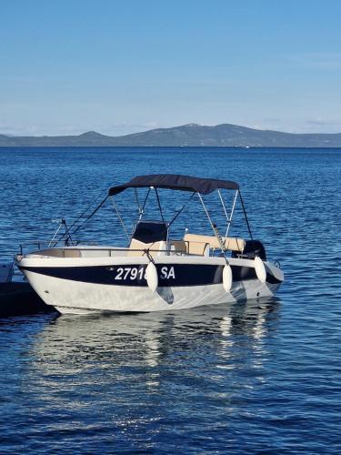 a small boat sitting in the middle of the water at Holiday home with swimming pool - Dugi otok, Zman in Žman