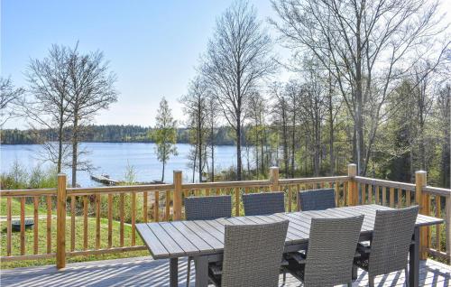 a table and chairs on a deck with a view of a lake at Awesome Home In Backaryd in Backaryd