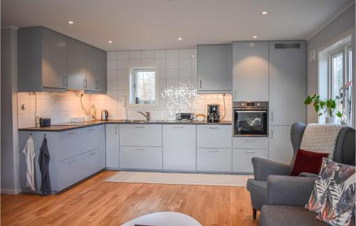 a kitchen with white cabinets and a couch in a room at Awesome Home In Backaryd in Backaryd