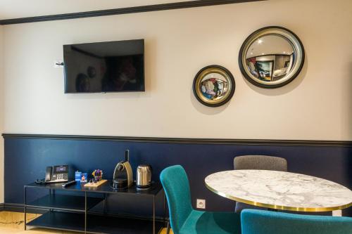 a room with a table and chairs and a mirror at Best Western Les Bains Hotel et SPA in Perros-Guirec