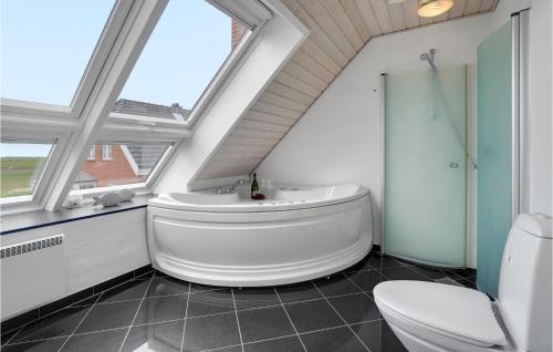 a bathroom with a large white tub and a toilet at Holiday Home Sdr Frankel Rømø in Rømø Kirkeby