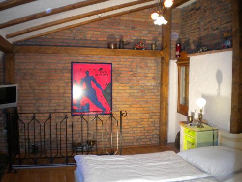 a bedroom with a bed and a brick wall at Casa Rozelor in Braşov