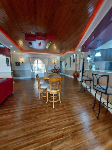 a living room with a table and chairs on a wooden floor at 8 bedroom in Nanyuki with pool in Ol Pejeta Conservancy