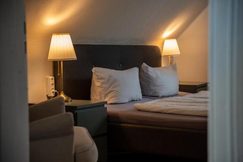 a hotel room with a bed with two pillows at Hirsch-Apartment-5 Eulennest in Bad Harzburg
