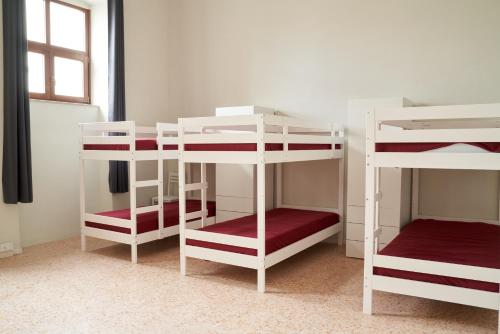 a room with three bunk beds in a room at HUB Portanova in Trani