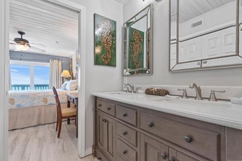 a bathroom with a double sink and a bedroom at Dottie's Sandbar in Navarre
