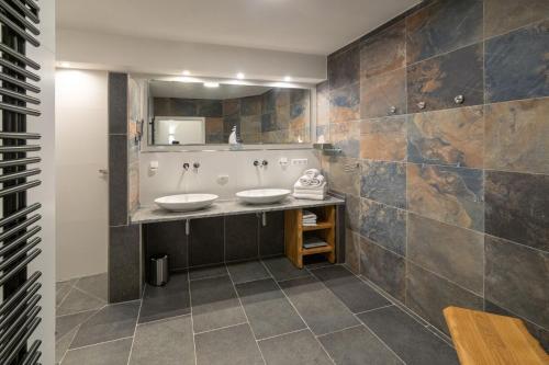 a bathroom with two sinks and a mirror at Luxus 5 Sterne Ferienhaus Voslapp in Norden