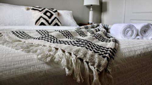 a bed with a black and white blanket on it at Chalet des Sources SPA Gazebo panoramique in Mont-Blanc