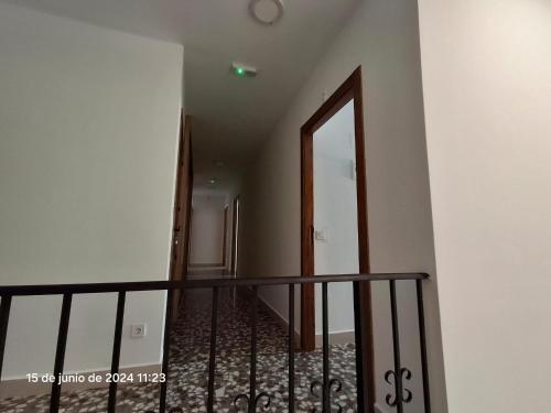 a hallway with a staircase with a mirror and a door at Conde Lucanor in Belmonte