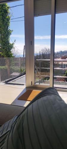 a bedroom with a large window with a view of a patio at La Cueva del Sacristán in Luanco