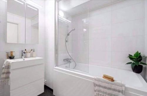a white bathroom with a shower and a sink at Miracle Tromso, cozy double bed private room in a shared apartment with Stunning Tromso Views in Tromsø