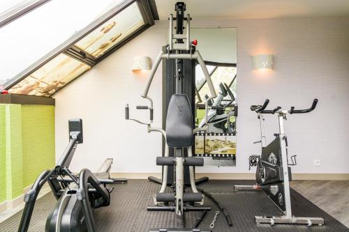 a gym with treadmills and elliptical machines at Best Western Les Bains Hotel et SPA in Perros-Guirec