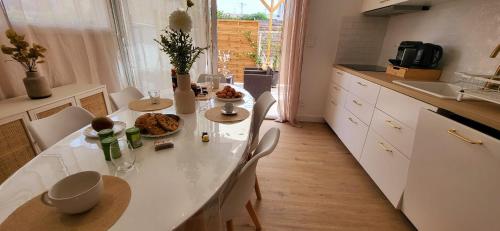 Domino 1 Superbement rénové - 2 chambres - Terrasse à 300m plage commerces في لو غراو دو روا: مطبخ مع طاولة وكراسي في مطبخ