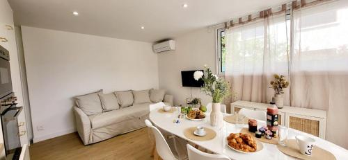 Domino 1 Superbement rénové - 2 chambres - Terrasse à 300m plage commerces في لو غراو دو روا: غرفة معيشة بها طاولة وأريكة